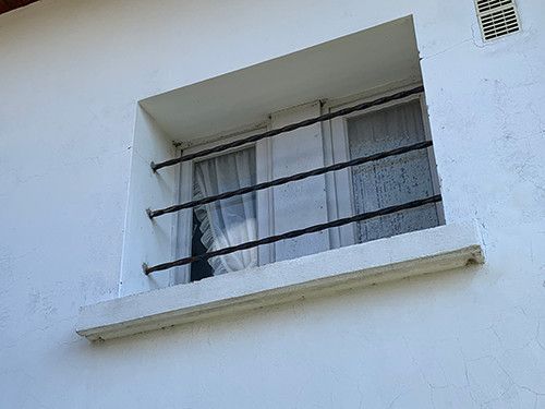 De simples barres en acier permettent de protéger cette fenêtre facilement accessible - Cliché C.P.