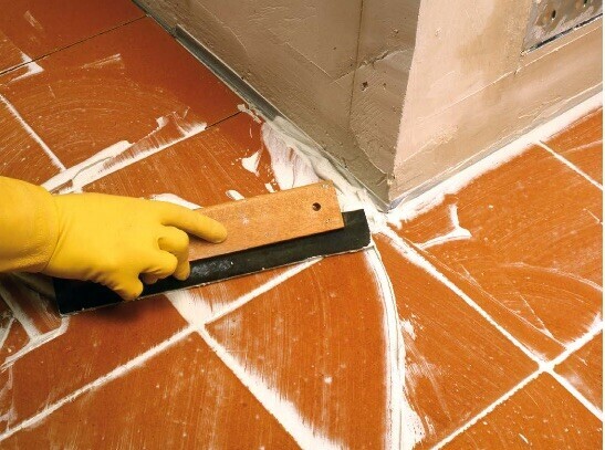 On étale la barbotine avec une raclette en caoutchouc pou bien remplir les joints - doc. coll. C.P.