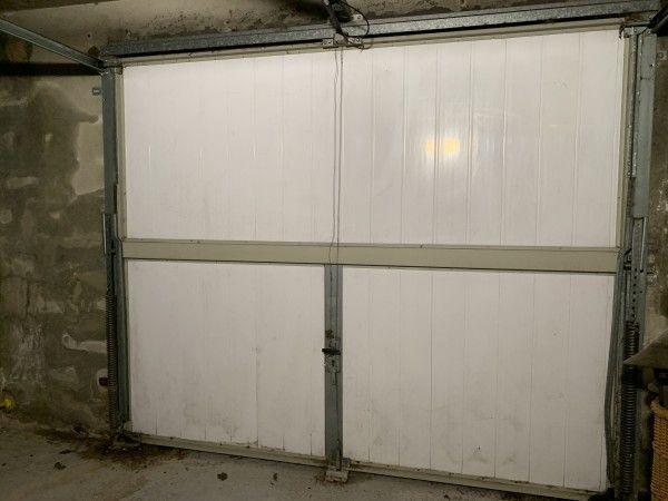 Le garage, s'il n'est pas chauffé, n'est pas concerné par la réglementation thermique. Sa porte (ici en PVC) n'est pas isolée d'origine. - cl. C.P.